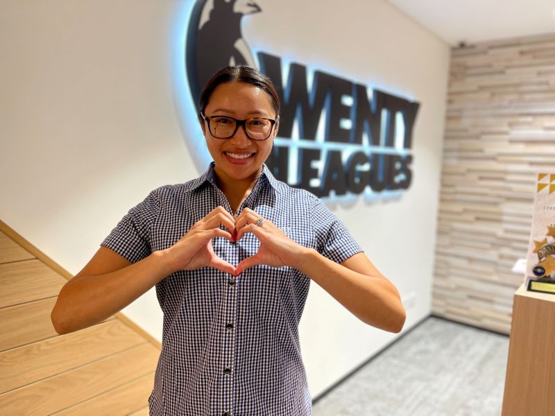 Staff member makes heart symbol with hands in front of club logo
